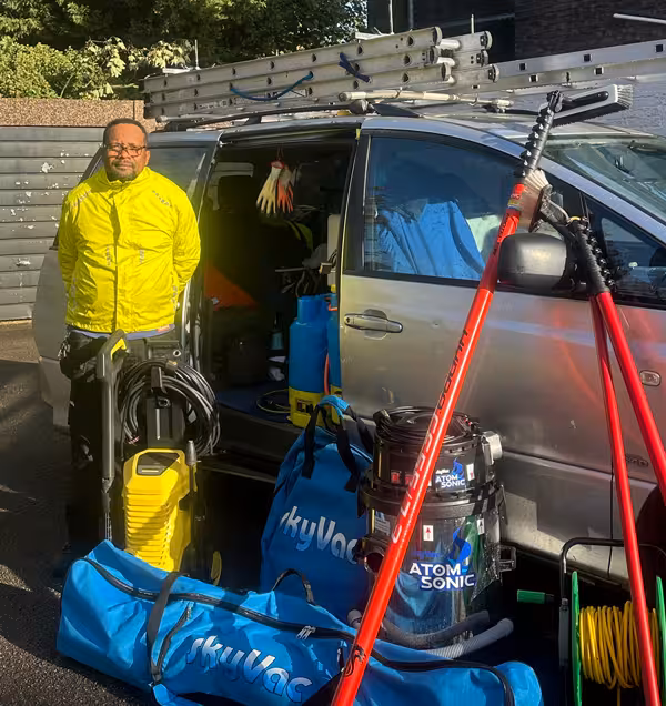Mishael, owner of Deionised Exterior Cleaning, with his van, water-fed poles and gutter vacuum